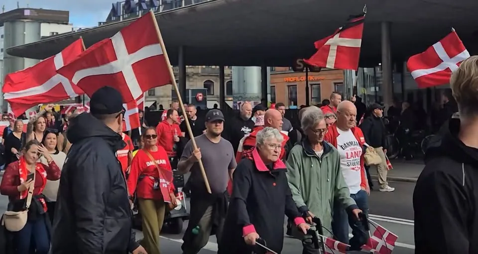 Deltagere går gennem København med Dannebrog